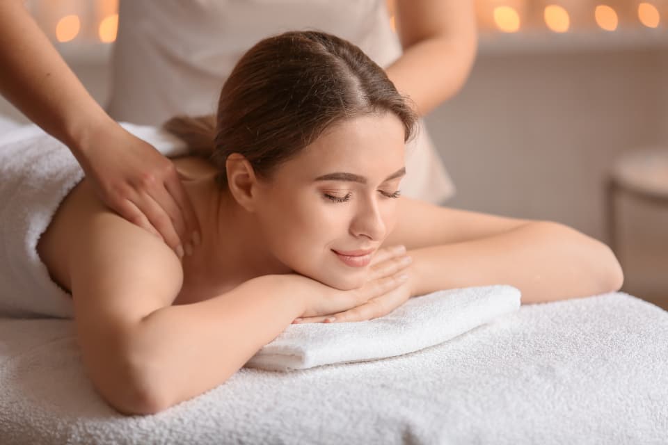 Client resting on a treatment table by candlelight